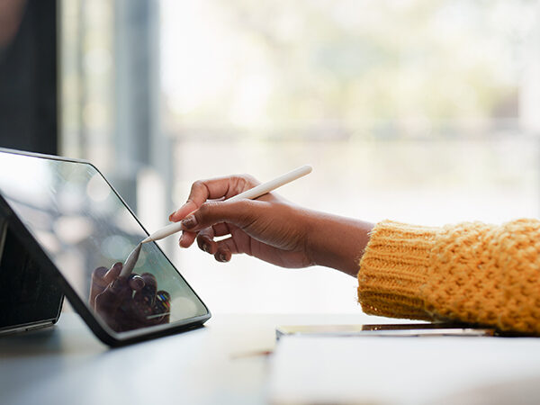 Women using stylus on tablet.