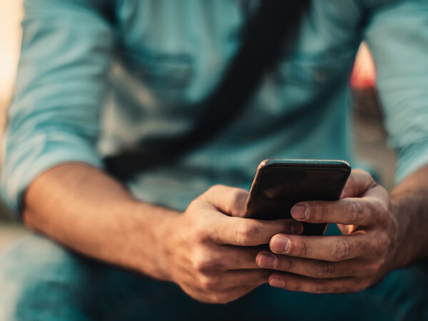 Young Male on Cell Phone. Close up Hands.