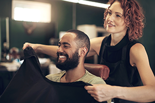 Women cutting man's hair