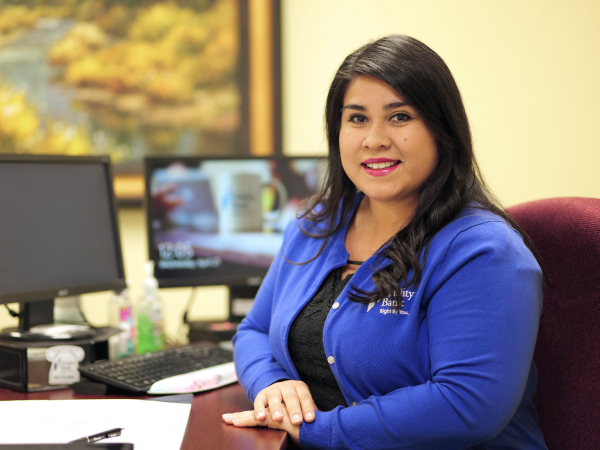 A Fidelity Bank employee behind a desk